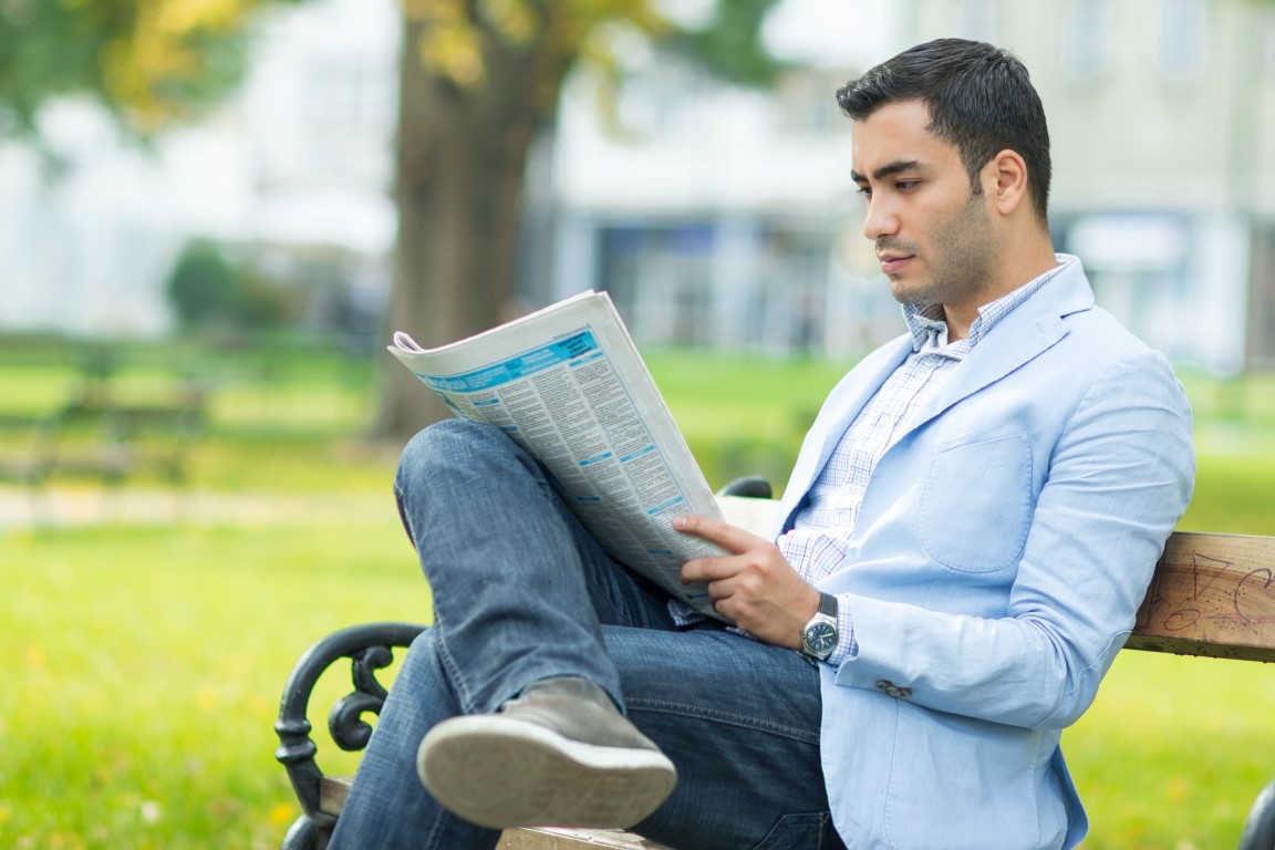 Прочитали в газете книги. Мужчина читает газету. Человек с газетой. Парень с газетой. Человек сидит с газетой.